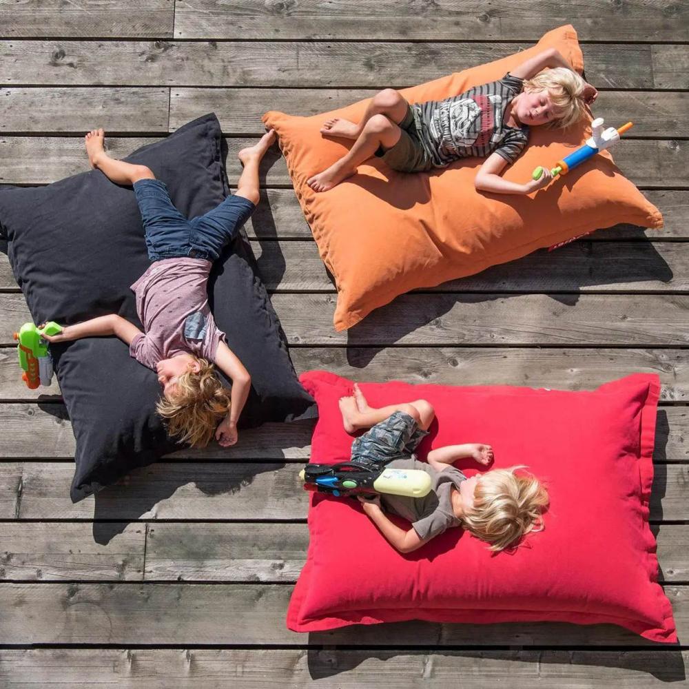 Christmas gift ideas with three kids lying on bean bags, offering a fun seating options for indoors and outdoors gatherings. 