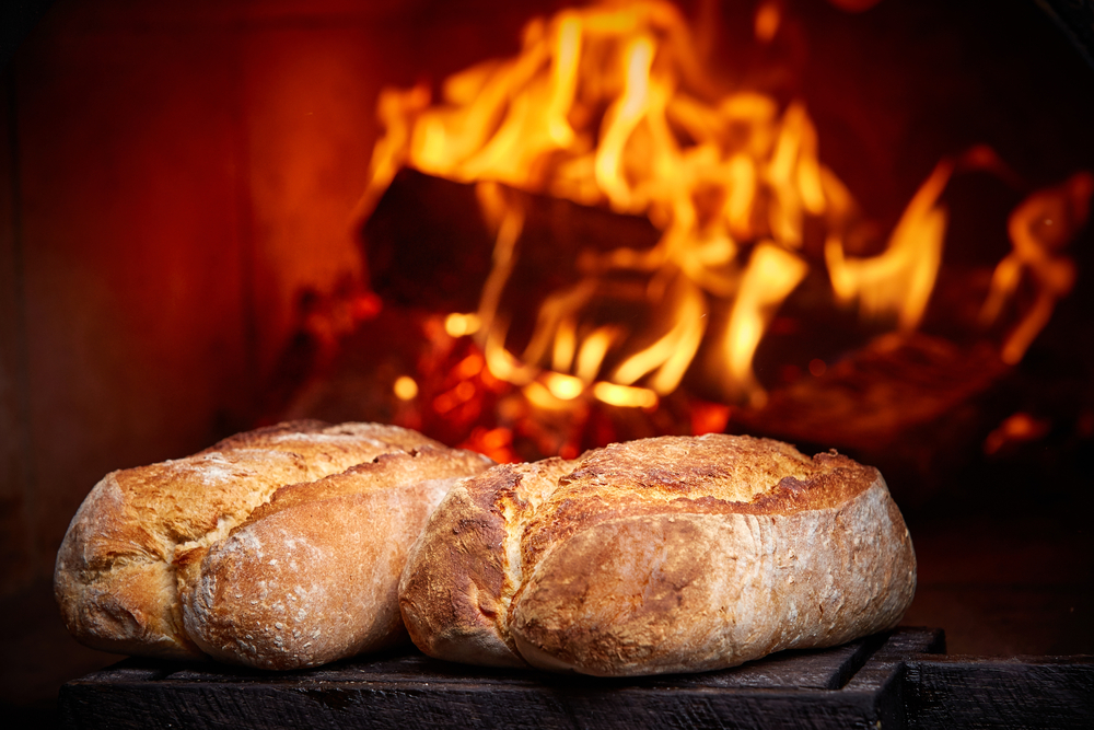 Wood-burning oven with artisanal bread baking using an Alfa Forni oven.