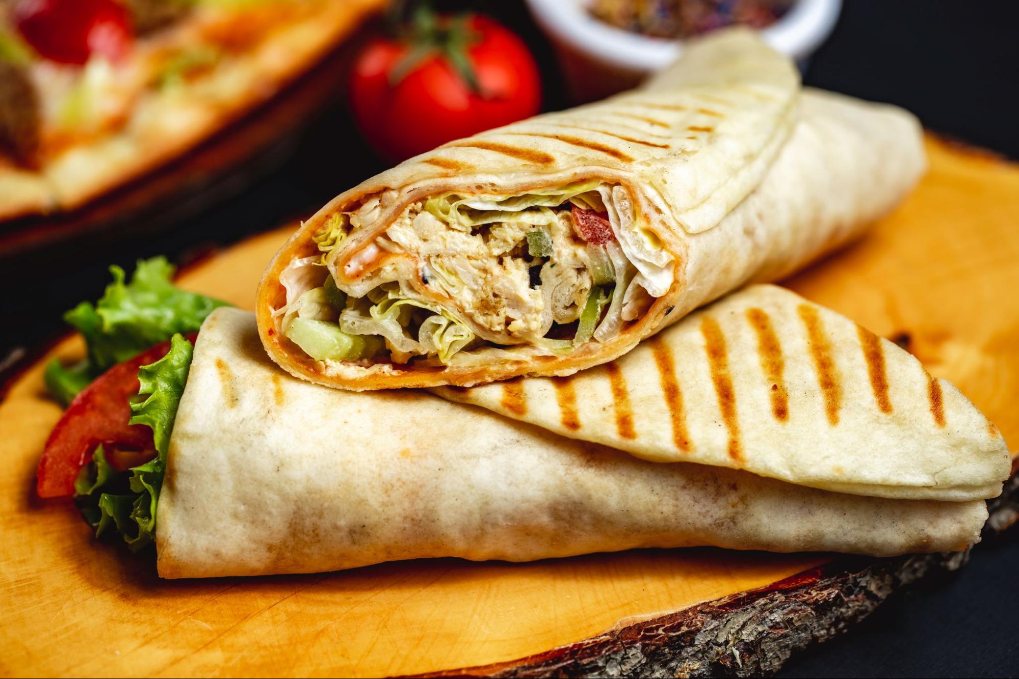 Arabic-style chicken shawarma wraps filled with spiced meat, fresh veggies, and garlic sauce.