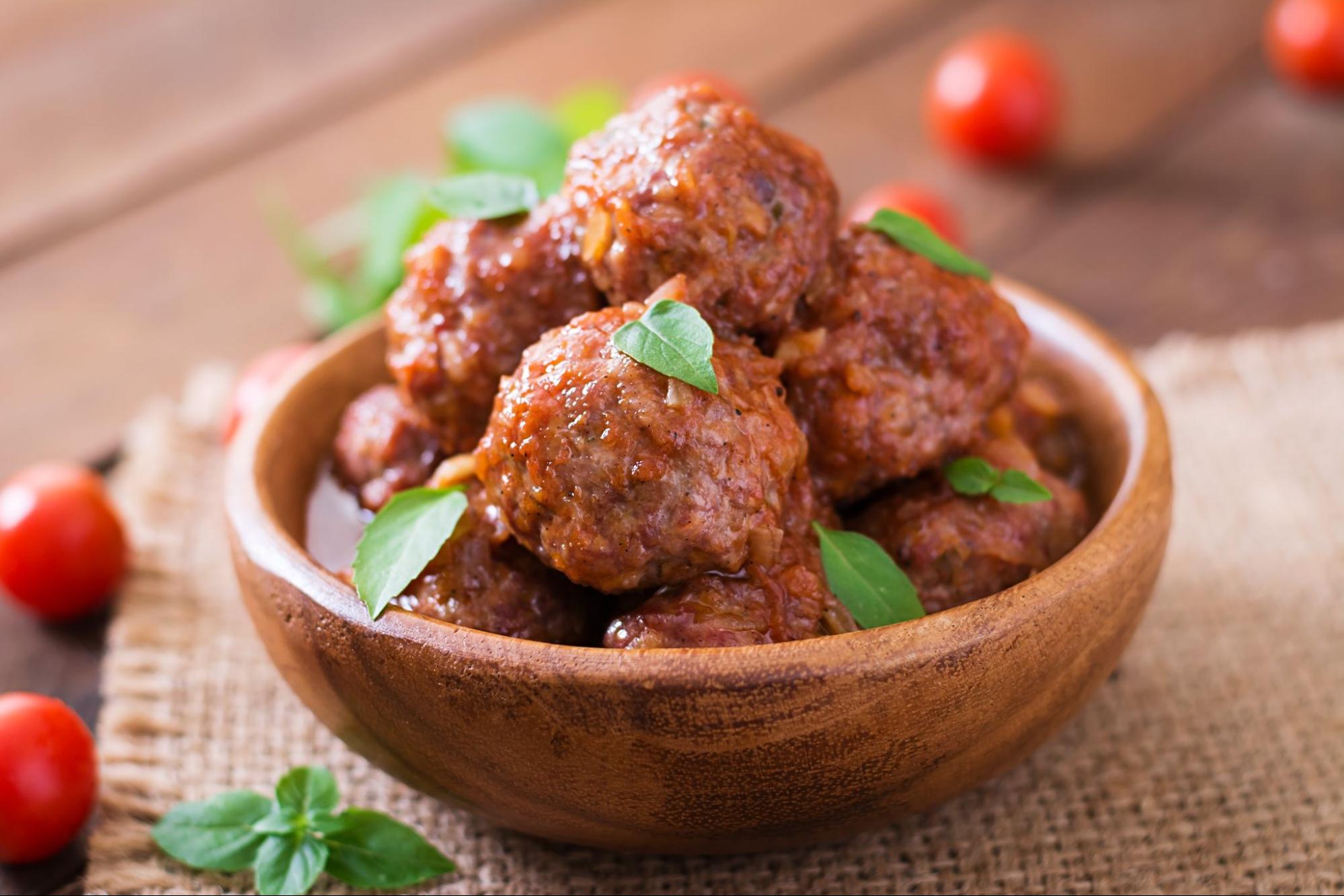 Baked kofta meatballs served in rich tomato sauce, garnished with herbs and paired with flatbread or rice.